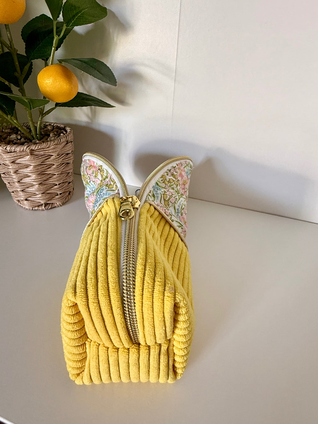Grande trousse artisanale Maison Maélia posée à plat, velours côtelé jaune texturé et fermeture éclair dorée, vue de dessus