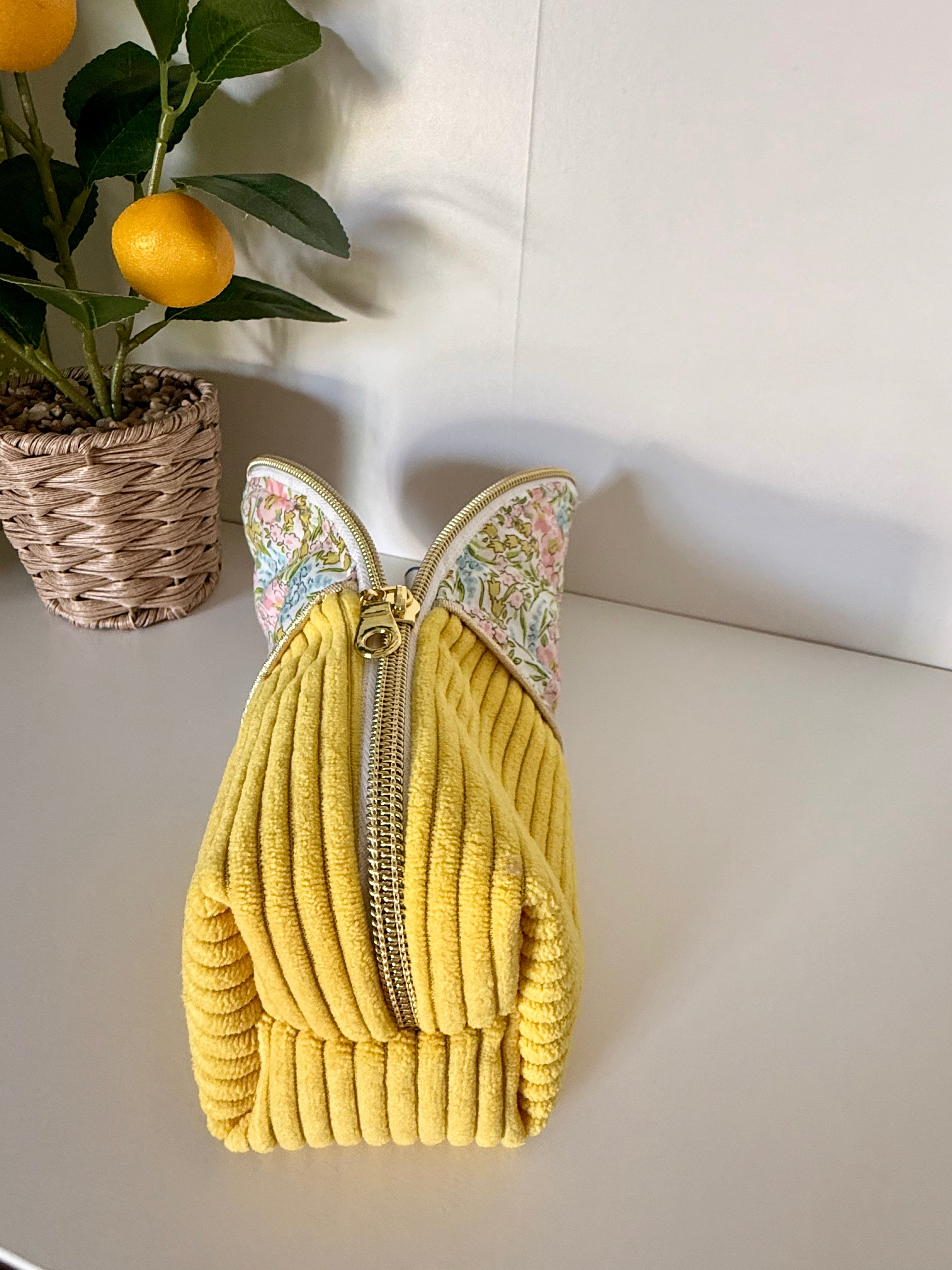 Grande trousse artisanale Maison Maélia posée à plat, velours côtelé jaune texturé et fermeture éclair dorée, vue de dessus